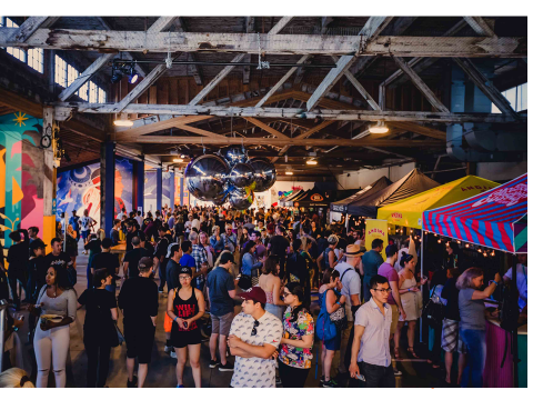 People wander through a crowded room full of stalls on Granville Island